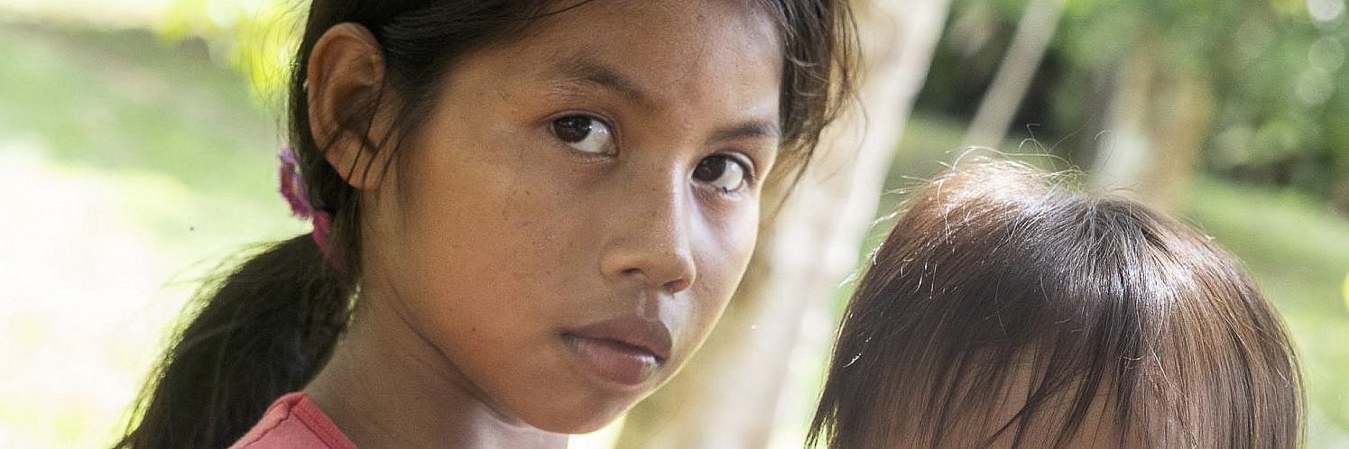 Ein junges Mädchen aus dem Amazonas-Gebiet hält ein Kleinkind auf dem Arm