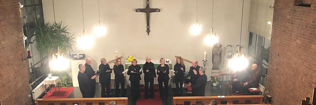 Die gemischtstimmige Schola singt vor dem Altar stehend in der Linterer Kirche.