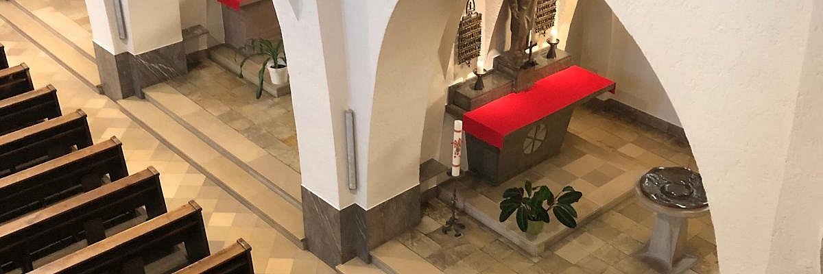 Blick von der Empore der Pallottinerkiche St. Marien in eine Kapelle mit Taufstein im Seitenschiff