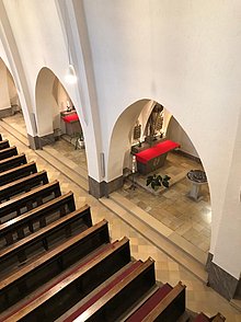 Blick von der Empore der Pallottinerkiche St. Marien in eine Kapelle mit Taufstein im Seitenschiff