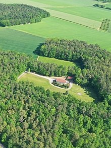 Zeltplatz mit Haus inmitten eines Waldes