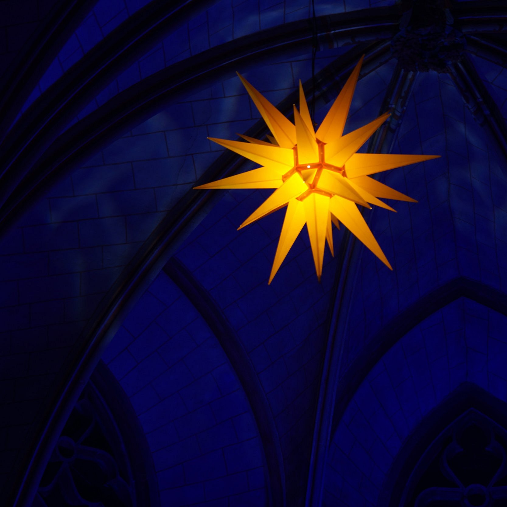 Leuchtender elektrischer Stern in in einer dunklen Kirche