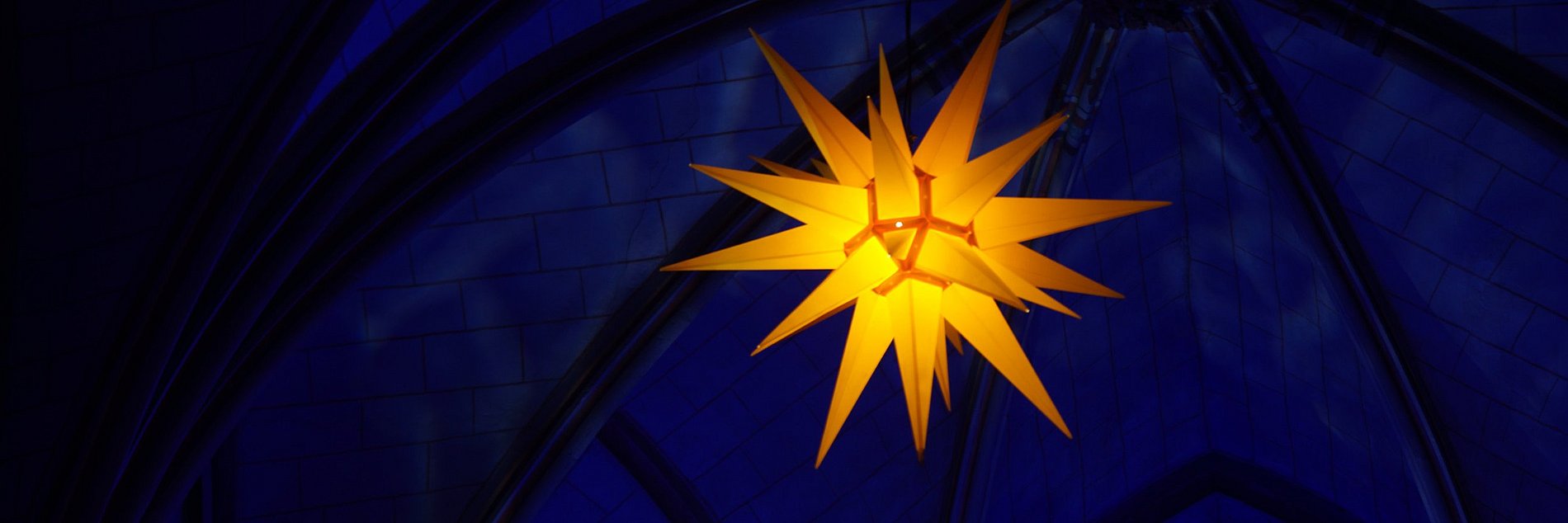 Leuchtender elektrischer Stern in in einer dunklen Kirche