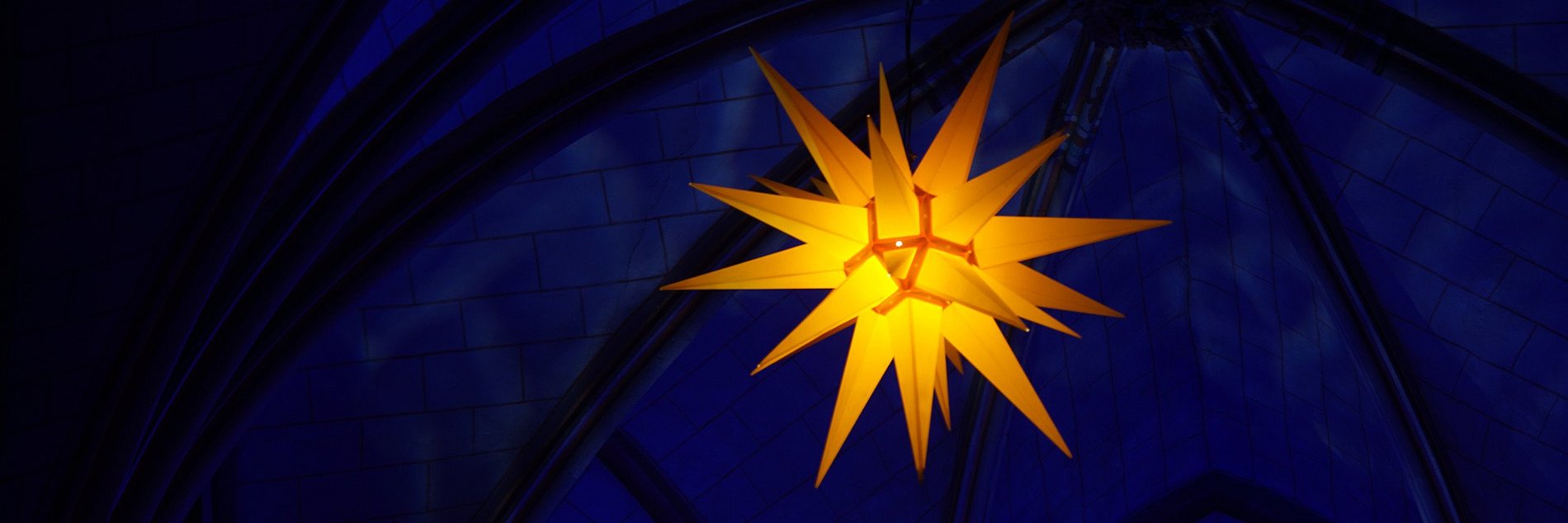 Leuchtender elektrischer Stern in in einer dunklen Kirche