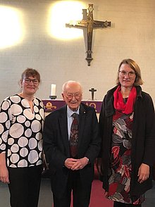 5 Personen stehen nebeneinander vor dem Altar