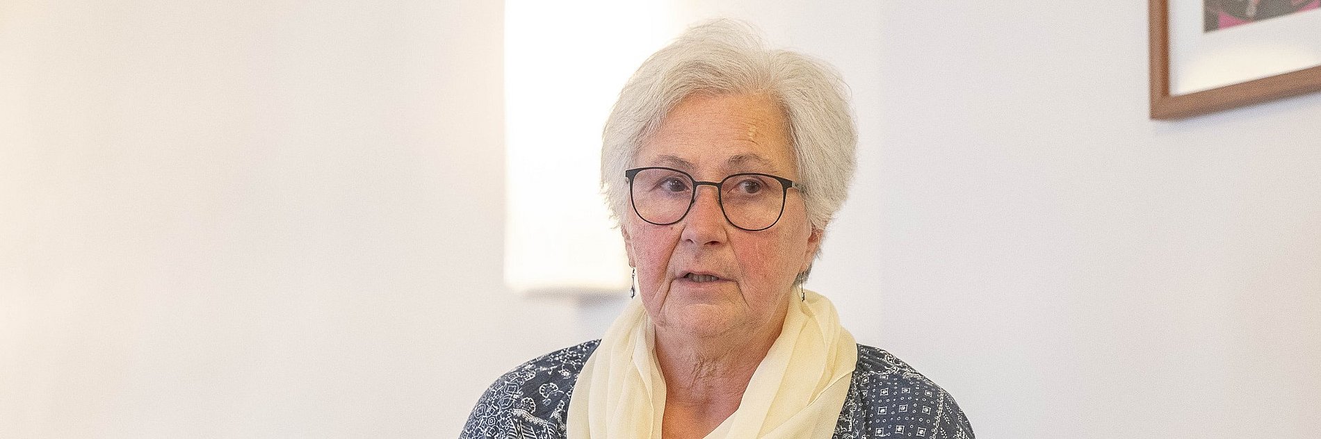 Eine Frau hält eine aufgeschlagene Bibel in der Hand.
